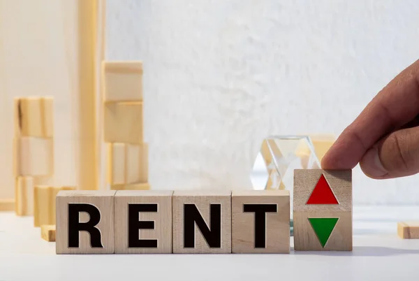 Wooden blocks with the word Rent, house and up arrow. The concept of the high cost of rent for an apartment or home. Interest rates are rising. Real estate market. Increased demand for rental property