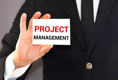 İş adamının elinde metin PROJECT MANAGER yazılı bir kart tutmasına yakın plan, yumuşak odaklı iş konsepti resmi