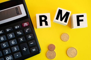 Emeklilik Fonu için RMF metni ahşap bloklardan yapılmış ve cam domuz kumbarasından dökülen paraların fotokopi alanı ile birlikte masaya dökülmüş. Vergilendirme ve yatırım planlama kavramı