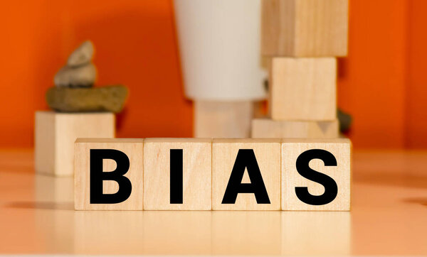 Слово "BIAS" пишется деревянными буквами на белом фоне..