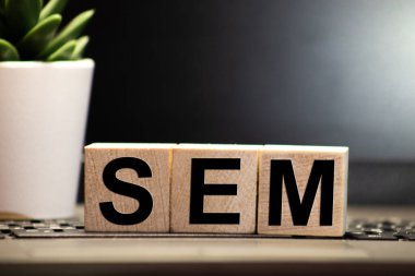 3 Oyuncak Ahşap Blok ve Harflerle SEM Açık Gri arkaplanı olan tahta bir masa üzerinde