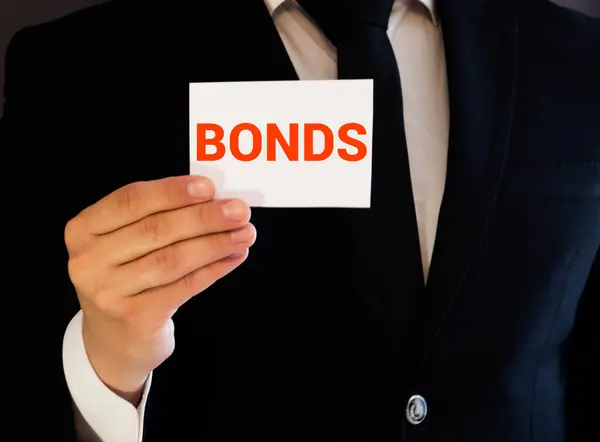 Hombre Sosteniendo Folleto Con Texto Bonds Sobre Fondo Gris Prepárate — Foto de Stock