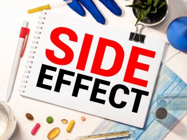 Arka planda tıbbi ekipman bulunan tablet ekranında yan etki sözcüğü