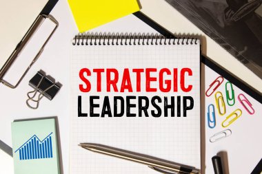 STRATEJİK DEVELOPMENT planlama metni. Çizelge, kağıt, kalem ve gözlüklü kavramsal arkaplan