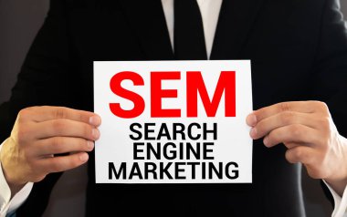 Tahta bir masada elinde kalem tutan biriyle SEM mesajı.