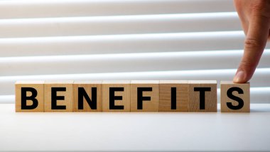 Tahta blokta BENEFITS kelimesi yazılı. Ahşap masa üzerindeki BENEFITS metin desing, konsept için