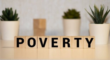 Tahta blokta yazan yoksulluk kelimesi. Yoksulluk metni ahşap masa üzerinde desing için, konsept.