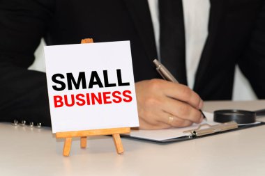 Gülen adamın tuttuğu tahtadaki küçük iş sözcükleri.