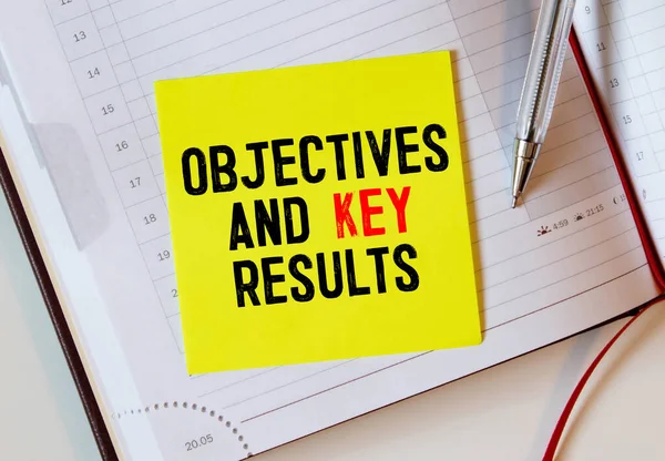 Objective Key Results OKR text in the office notebook. View from above.