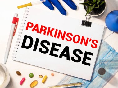 Parkinson hastalığı metni kalp atışı diyagramı, steteskop, lezzetli yeşil elma, mezura ve ahşap masa üzerinde mavi dambıl - tıbbi, sağlık ve hastalık konsepti
