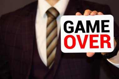 İşadamı şeffaf tahtayı metinle işaret ediyor: Oyun bitti
