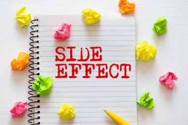 Tıbbi konsept olarak tahta arka planda steteskop ve kalemle yan etkisi.