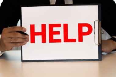 Elinde bir kağıt parçası tutan küçük kız. Önünde 