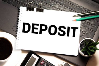 DEPOSIT - Sözcük beyaz kağıt üzerine yazılmış mavi masa üzerinde kalem ve planlayıcı ile