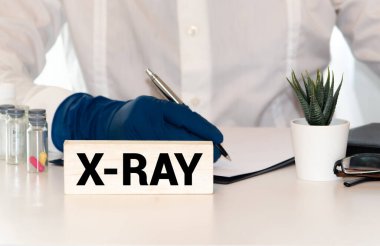 Mavi tıbbi masada üzerinde X-RAY yazan ahşap tablet.