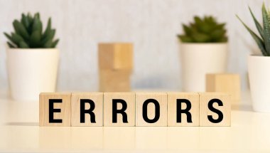 Tahta blokta yazılan hatalı sözcük. Ahşap masadaki hata metni desing, konsept.