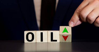 Düşen ya da yükselen petrol fiyatları kavramı, elle ahşap küpü kırmızı ve yeşil ok sembolüyle çeviriyor