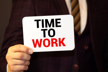 Üzerinde çalışma zamanı yazan siyah günlük, renkli tahtaların ahşap arka planında bir kalem. Çalışma zamanı..