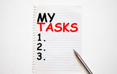 Görevlerimi gösteren bir not yazıyorum. İş fotoğraflarının sergilenmesi, genellikle belirli bir zamanda tamamlanması için tahtadan yapılmış klasik bir masanın üzerine yerleştirilen karton parçalarını gösterir..