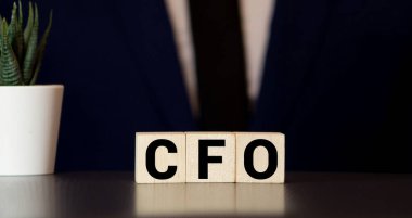 Finans Müdürü bir dizüstü bilgisayarın önünde tahta bir küpün üzerine yazılmış..