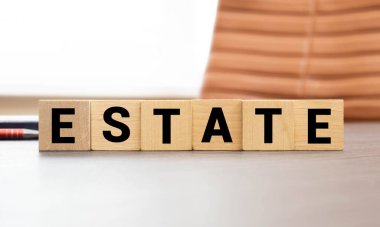 Emlak kelimesi günlükte tahtadan küplerin üzerine yazılıdır. İş konsepti.