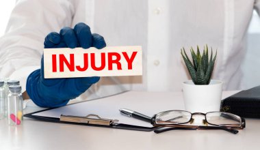 Kelime yazma, kişisel yaralanma iddiaları. İş ortamında yaralanmak ya da yaralanmak için iş kavramı. Elinde keçeli kalem, mandal tutan adam. Kahve fincanı ahşap masasını anımsatıyor..