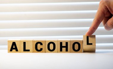 Tahta blokta yazan alkol kelimesi. Masada alkol metni, konsept.