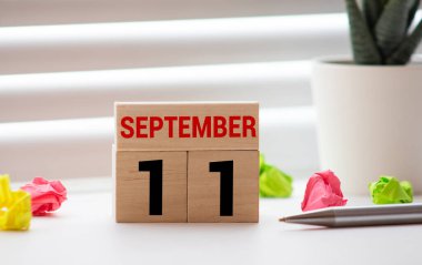 Beyaz blok takvimi sunum tarihi 11 ve Eylül beyaz duvar arkaplanında.