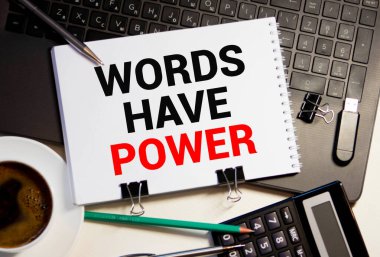 Kelimelerin Gücü Var tabiri bir kağıt parçasına basılmış ve kırmızı uyarı panosuna yapıştırılmış.