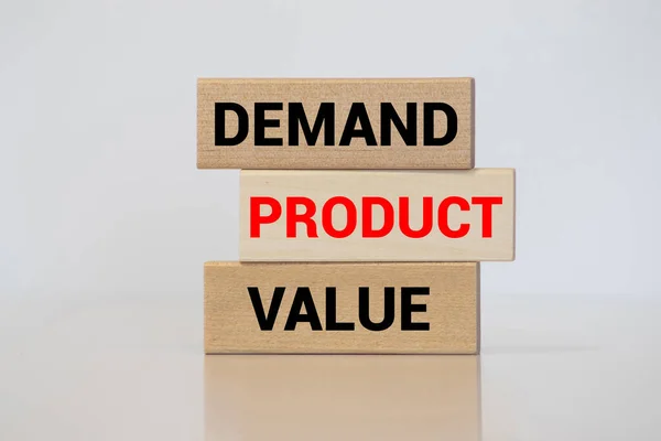 Product marketing concept. Business marketing words demand, product and value written on wooden blocks with a male hand placing the word product.