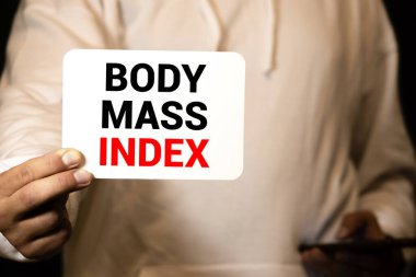 Defterde leziz yeşil elma, mezura, gözlük, bir şişe maden suyu ve ahşap zemin üzerinde vücut geliştirme araçları içeren vücut kütle indeksi - sağlıklı, egzersiz ve diyet konsepti