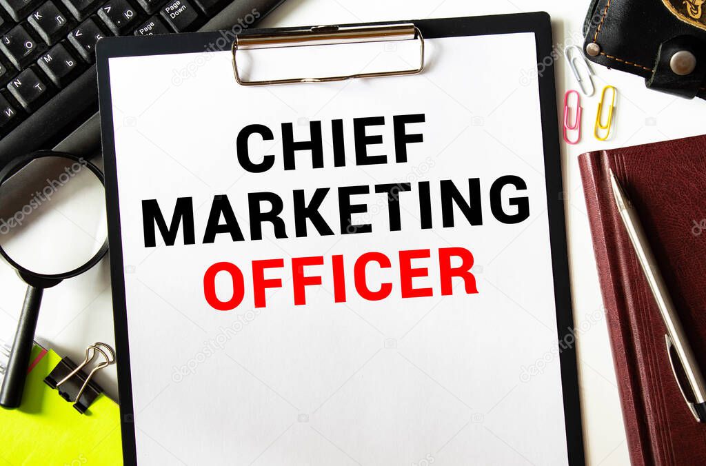 On the table are financial reports, a pen, a magnifying glass and a notebook with the inscription - CMO. Chief Marketing Officer.