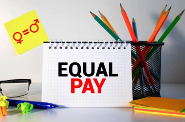 Bilgisayar faresi, kalemler, keçeli kalemler, sarı arka planda eşit ödeme içeren not defteri..