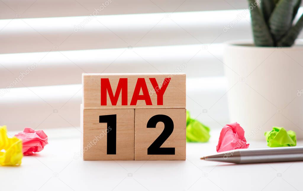 May 12th. Wooden cubes with date of 12 May on old blue wooden background