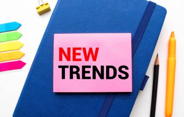 NEW TRENDS kahve ve gözlüklü not defterine yazılan kelime