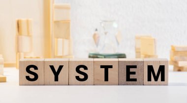 Sistem - yapı taşlarından yapılmış bir kelime. Siyah yazı tipiyle yazılmış bir sıra tahta küp siyah bir klavyede yer almaktadır..