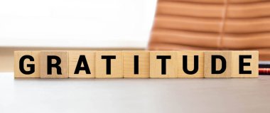 Tahta blokta minnet kelimesi yazılı. Minnettarlık metni ahşap masa üzerinde desing için, konsept