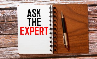 Uzmanlara sorun. Üzerinde uzmanlara sor yazan yapışkan bir not. Mantar panoya tutturulmuş.