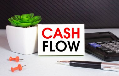 Hesap makinesi, kalem, para ve chart ile sarı kağıda yazılan nakit akışı. İş kavramı.