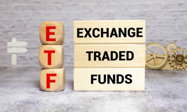 ETF, Exchange Traded Fund, hisse senedi piyasasında ticaret yapabilen gerçek zamanlı yatırım endeksi, alfabe alfabesiyle ETF kelimesinin şebeke hattı kağıdında oluşturulduğu küp tahta blok, arka planda rastgele blok.
