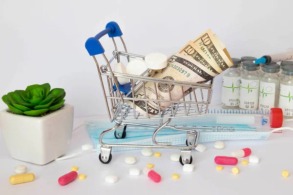 高価な薬の概念のコストが高いのです コインや紙幣の山やショッピングトロリーやカートに多くの丸薬 高価な薬と治療 オンライン薬局だ — ストック写真
