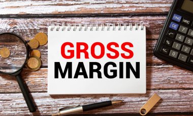 Tahta masadaki defter ve kalem, metin için kopyalama alanı, buruşuk sarı kağıt üzerinde kadın el yazısı PROFIT MARGIN, çalışma yeri, beyin fırtınası