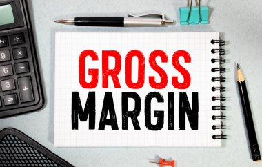 İş konsepti. Not defteri beyaz arka planda notlar, hesap makinesi, gözlük, kalem, kalem için beyaz kağıt metin PROFIT MARGIN sayfası