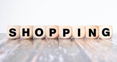 Ahşap blok ve arka planda alışveriş arabasıyla alışveriş yapma üzerine seçici odaklanma