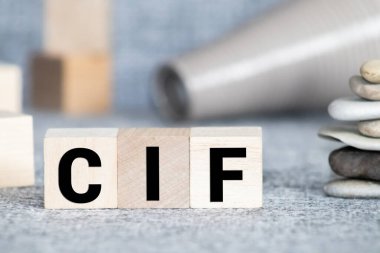 Hafif arkaplandaki tahta küplere sayılı CIF yazıları. İş konsepti.