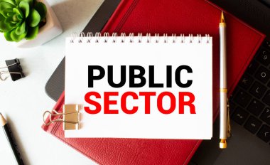 Kalemlerle birlikte bir deftere yazılmış Kamu Sektörü metni.