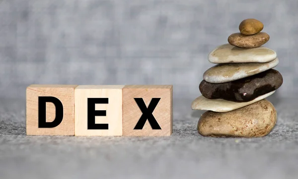 Ντεξ. ξύλινοι κύβοι με την επιγραφή dex στο φόντο των εικόνων των νομισμάτων των διαφόρων χωρών — Φωτογραφία Αρχείου