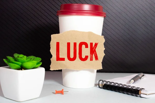 Good luck text on card on the table with sunny green park background.