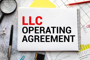 Llc İşletme Anlaşması, ahşap arka planda izole edilmiş bir evrak üzerine yazıldı.