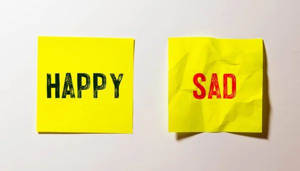 happy and sad word written on wood block. Top view concept. Isolated on dark background